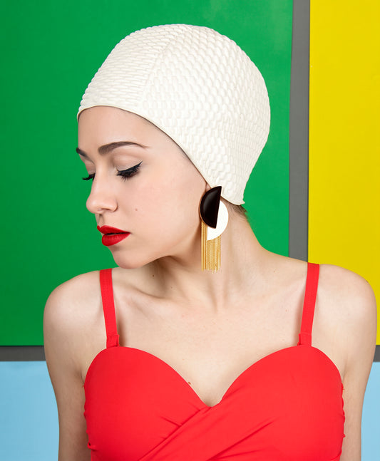 Modelo con gorro de baño blanco y bañador rojo luciendo los pendientes Java asimétricos esmaltados en negro
